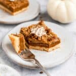 Pumpkin bars served on small white plates with whipped cream.