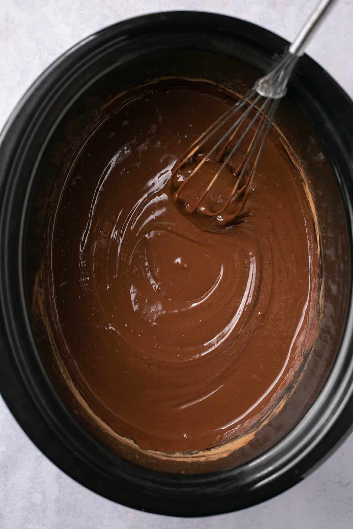 Whisking chocolate mixture in a crockpot.