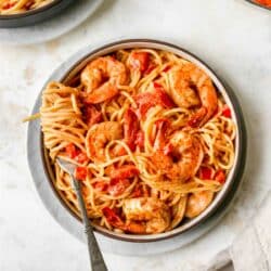 Creamy cajun shrimp pasta in a bowl with noodles swirled around a fork.