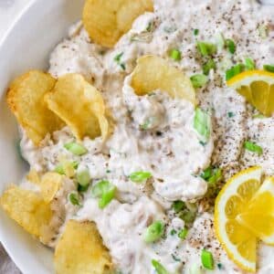 Potato chips dipped in clam dip.