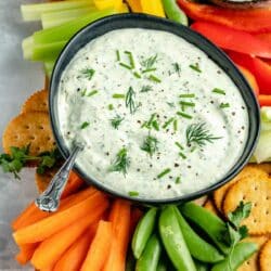 Cream cheese dip recipe garnished with fresh herbs and served with vegggies.