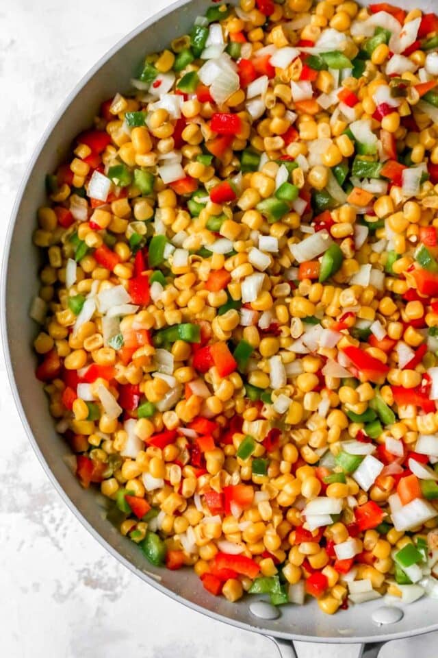Corn, red bell pepper and green bell pepper in a pan.