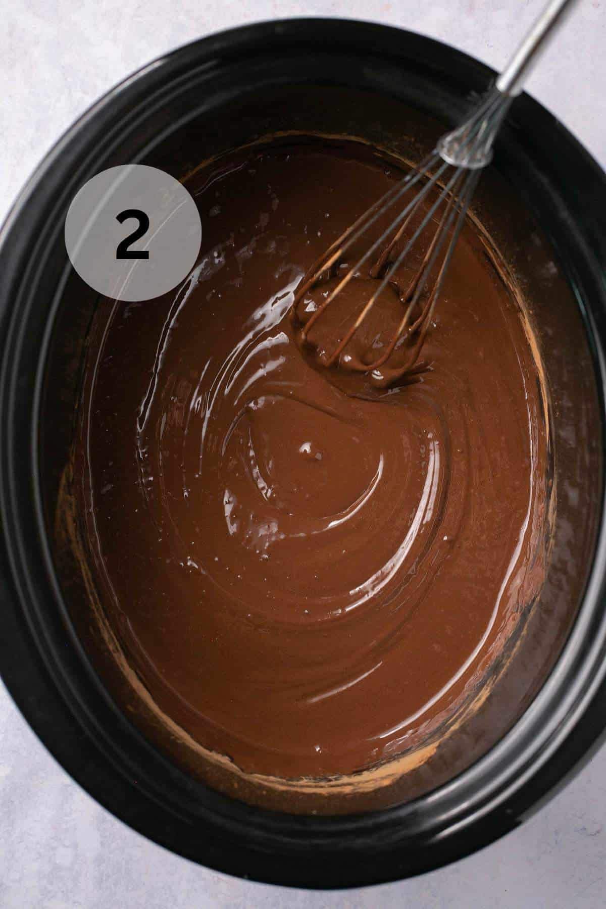 Whisking creamy chocolate mixture in a crockpot.