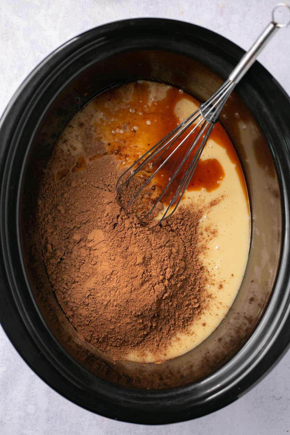 Whisking cocoa with sweetened condensed milk and vanilla.