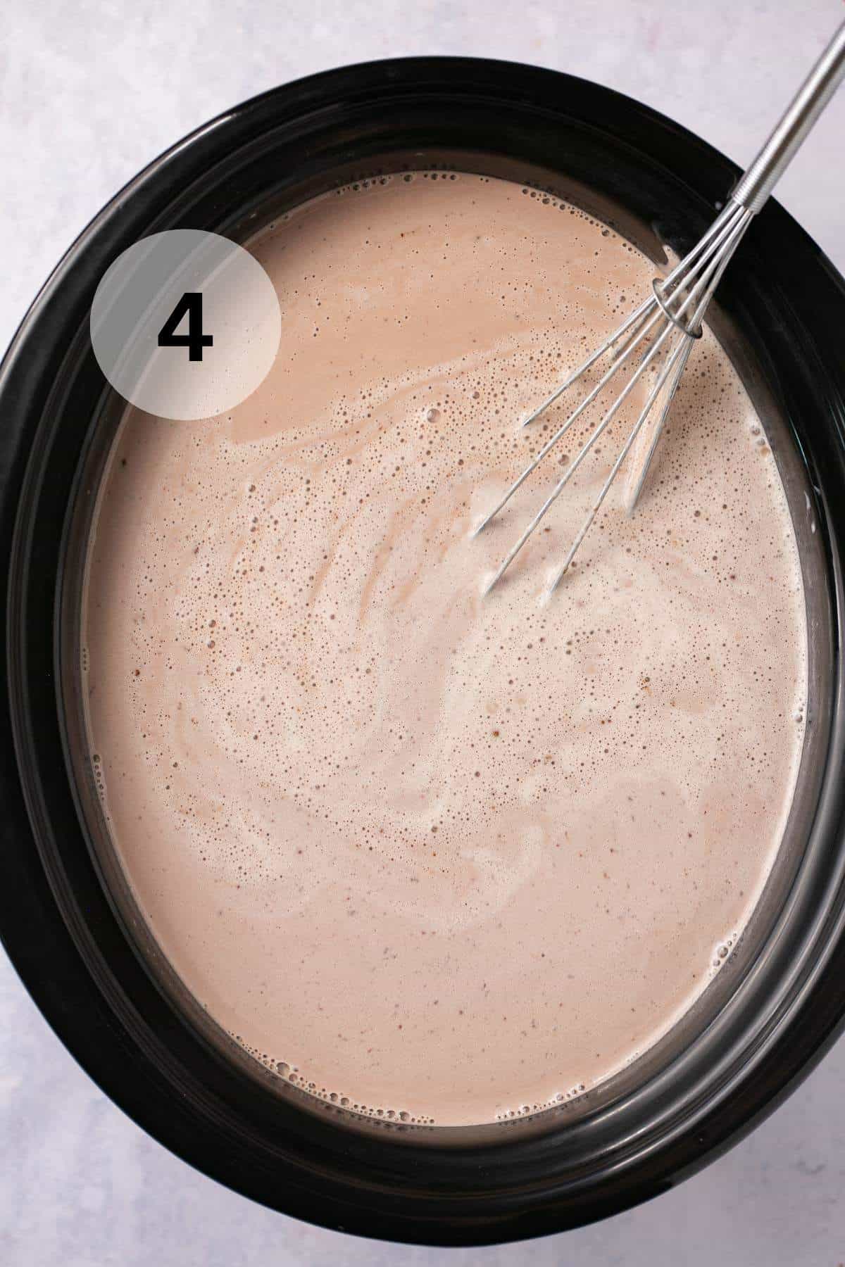 Whisking hot chocolate in a slow cooker.
