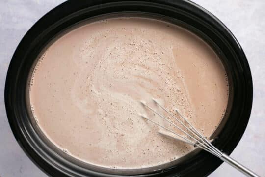 Whisking hot chocolate in a slow cooker.