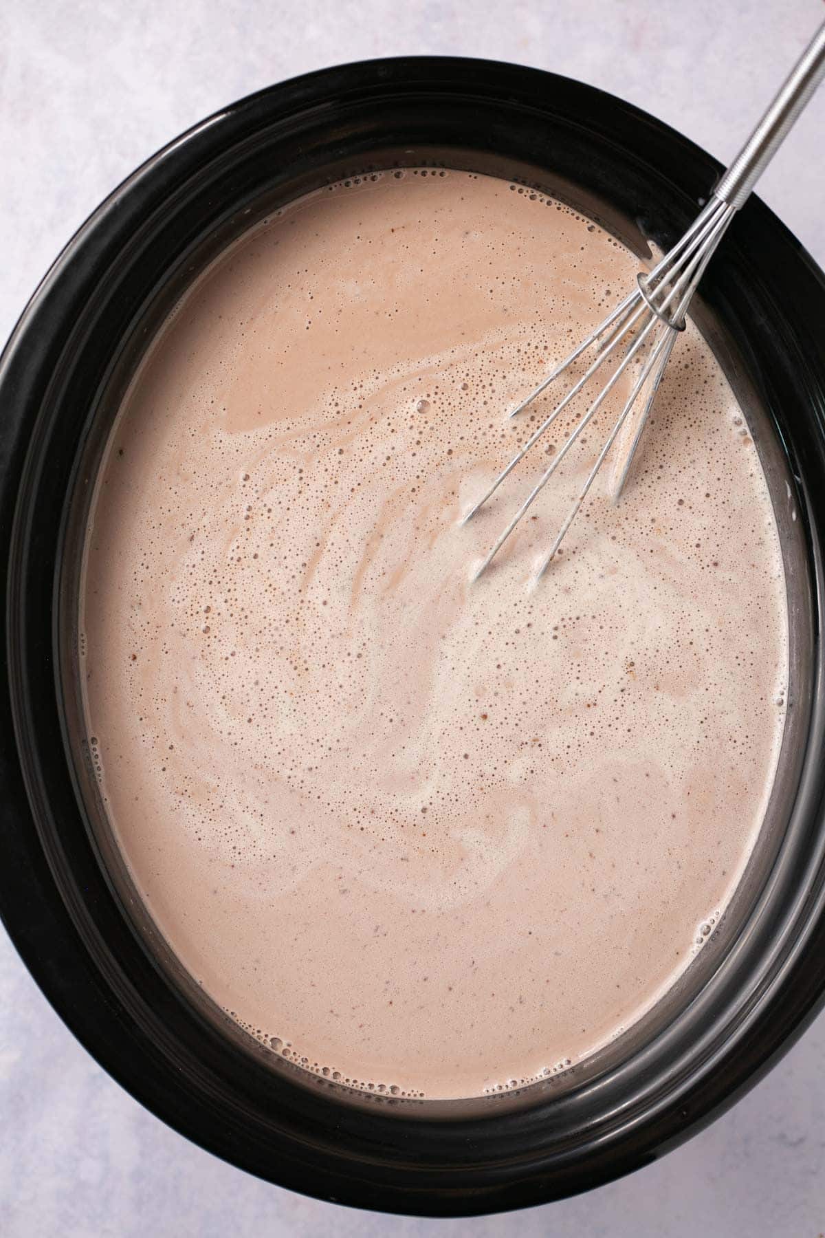 Whisking hot chocolate in a slow cooker.