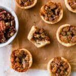 Mini pecan pies on parchment paper.