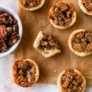 Mini pecan pies on parchment paper.
