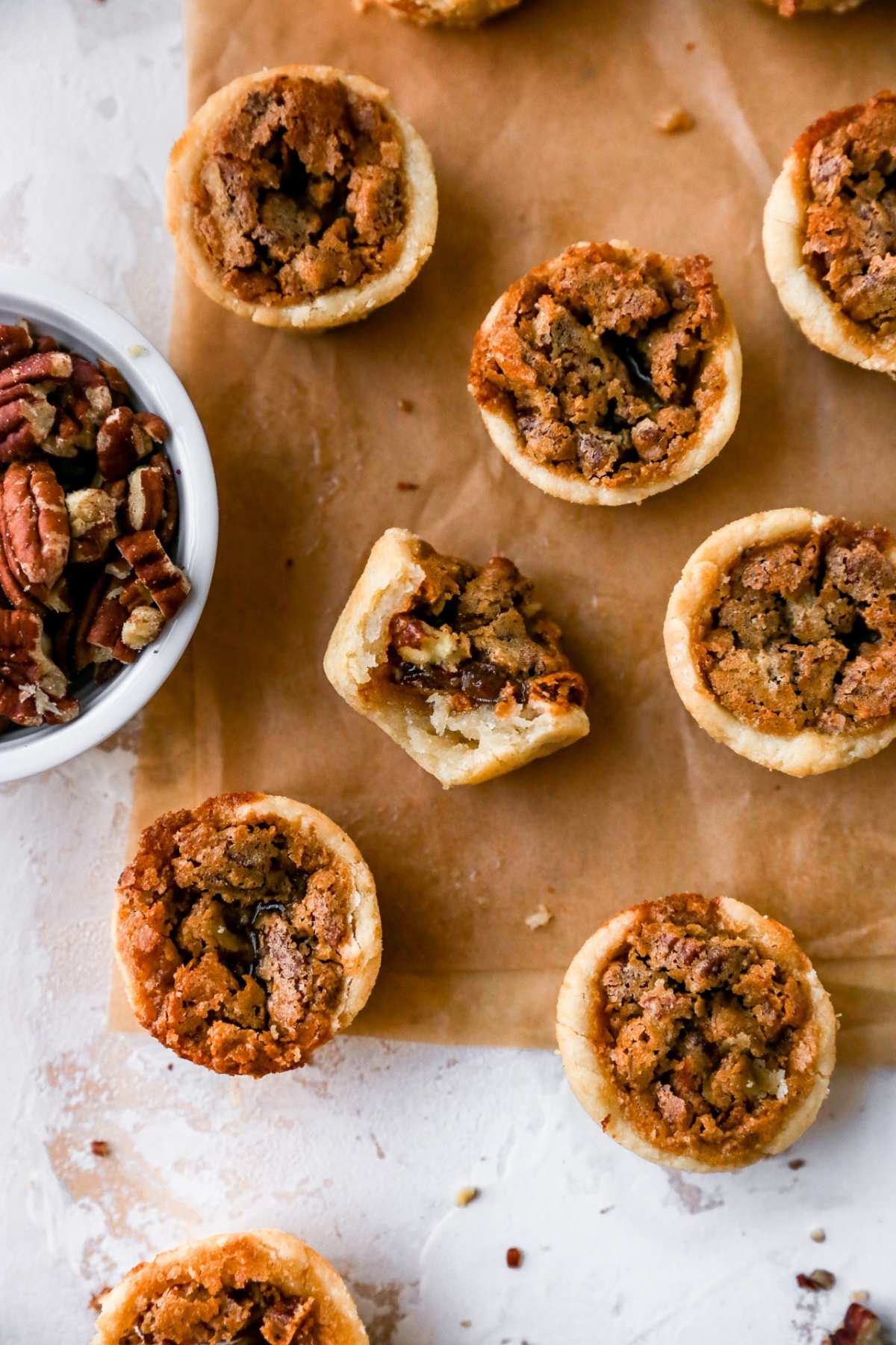 Mini pecan pies on parchment paper.