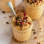 Pumpkin overnight oats in a small glass jar with a spoon.