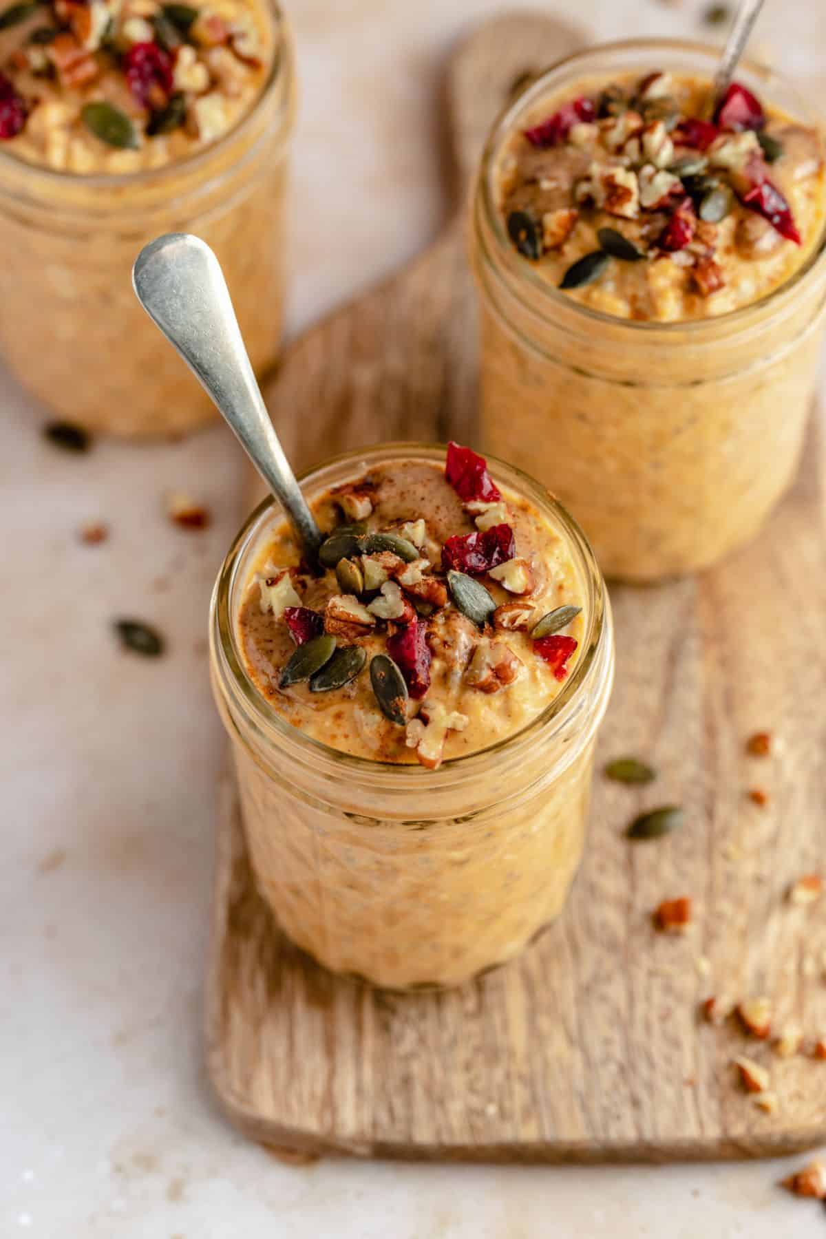 Pumpkin overnight oats in a small glass jar with a spoon.