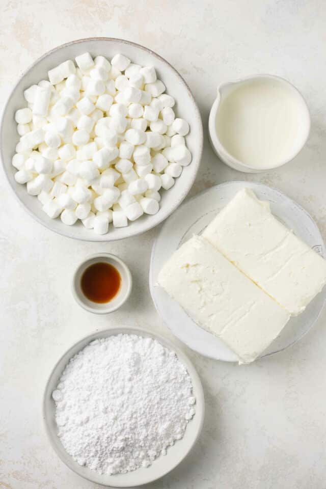 Marshmallows, vanilla, powdered sugar and cream cheese in small white bowls.