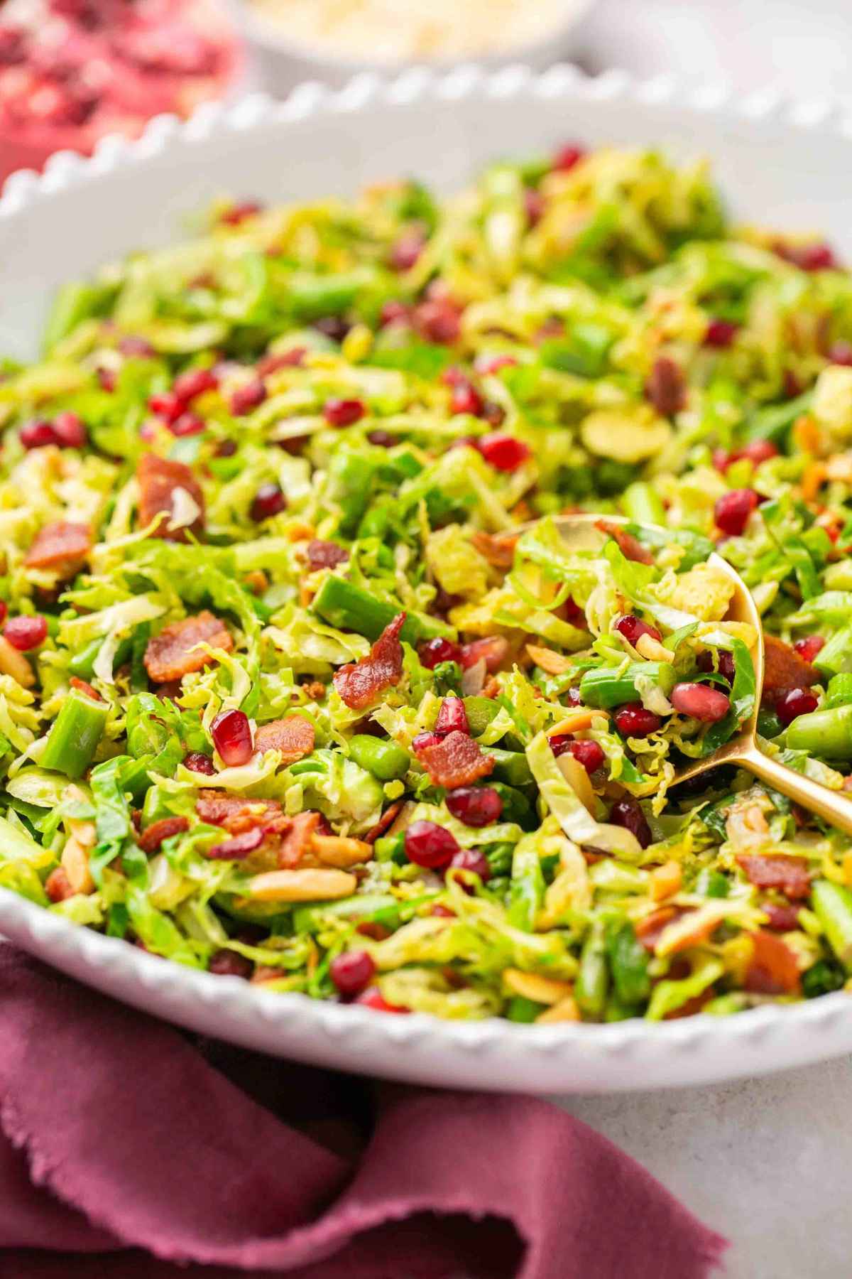 Shredded brussels sprouts salad served in a white serving bowl.