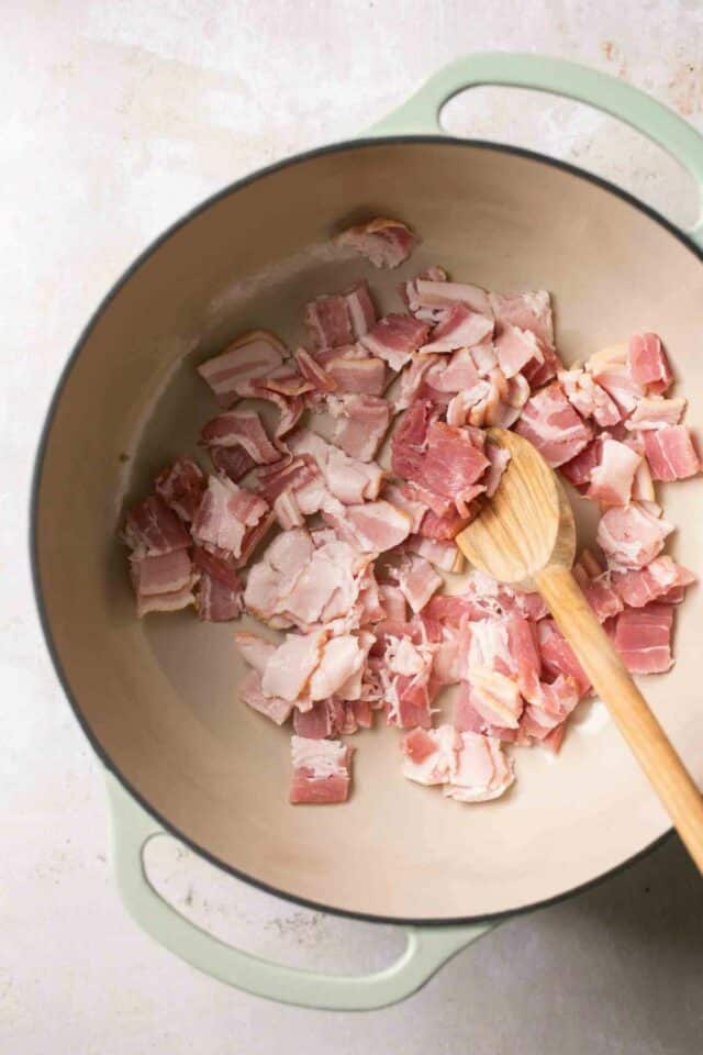 Cooking chopped bacon in a pot.