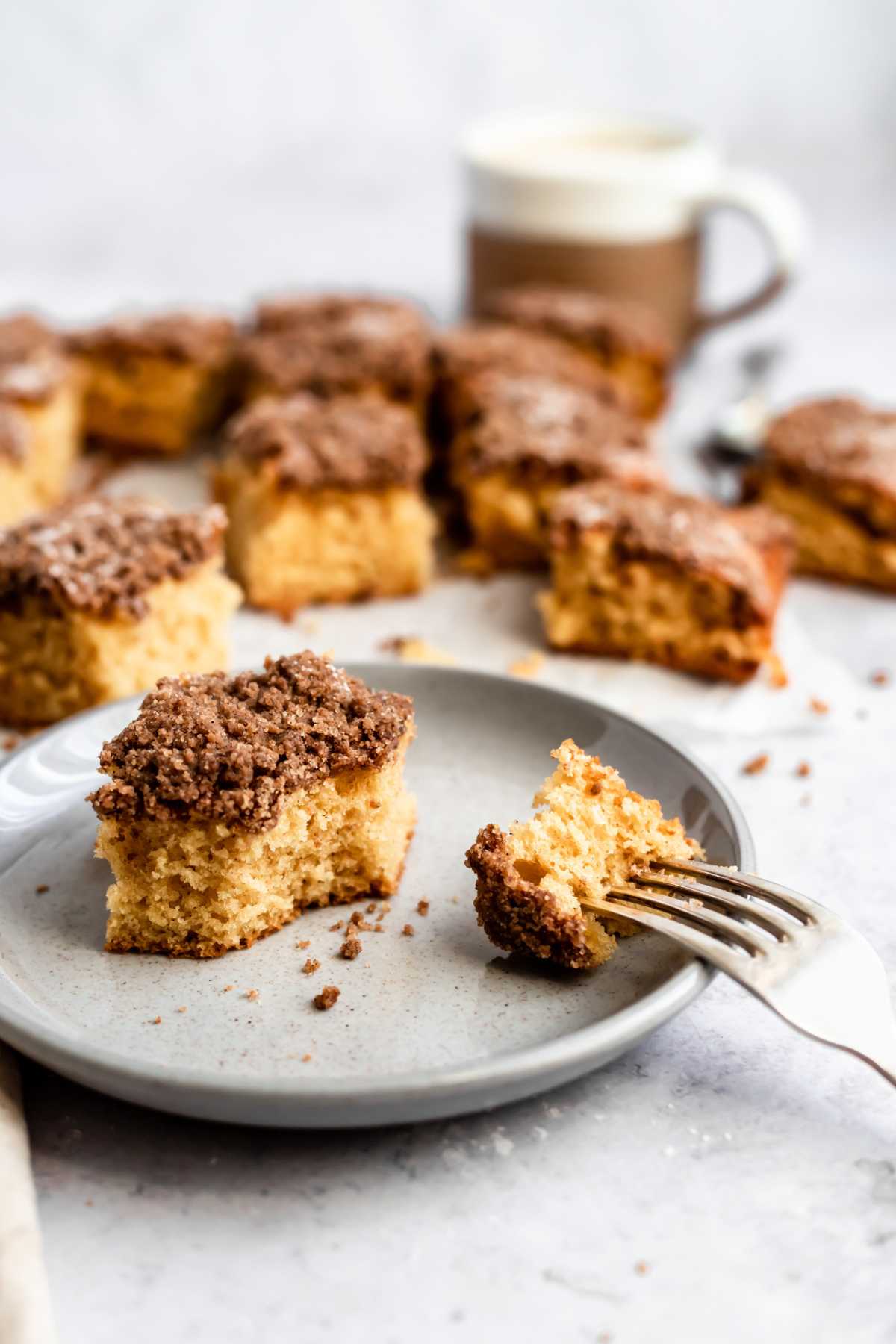 Piece of coffee cake on a plate with some on a fork.