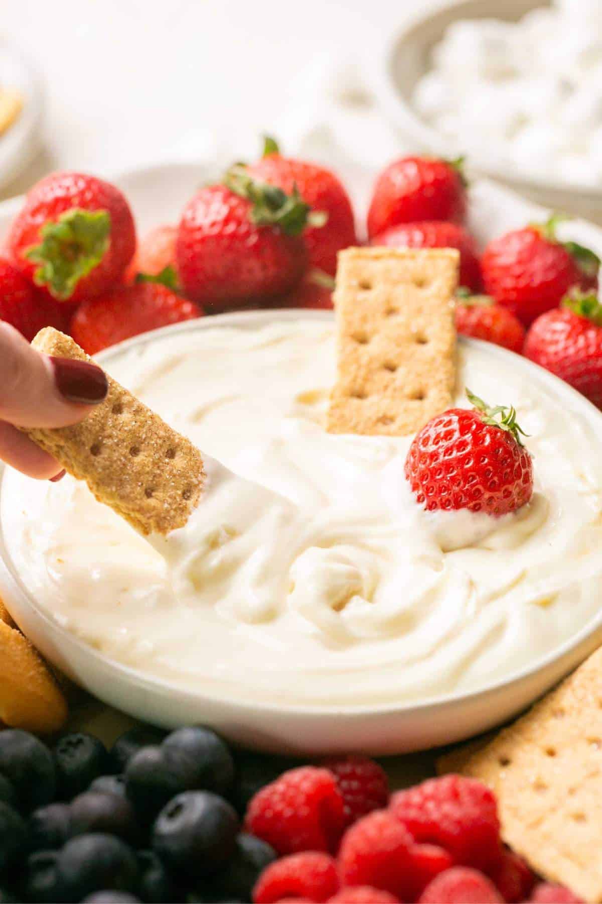 Dipping a graham cracker into fruit dip.