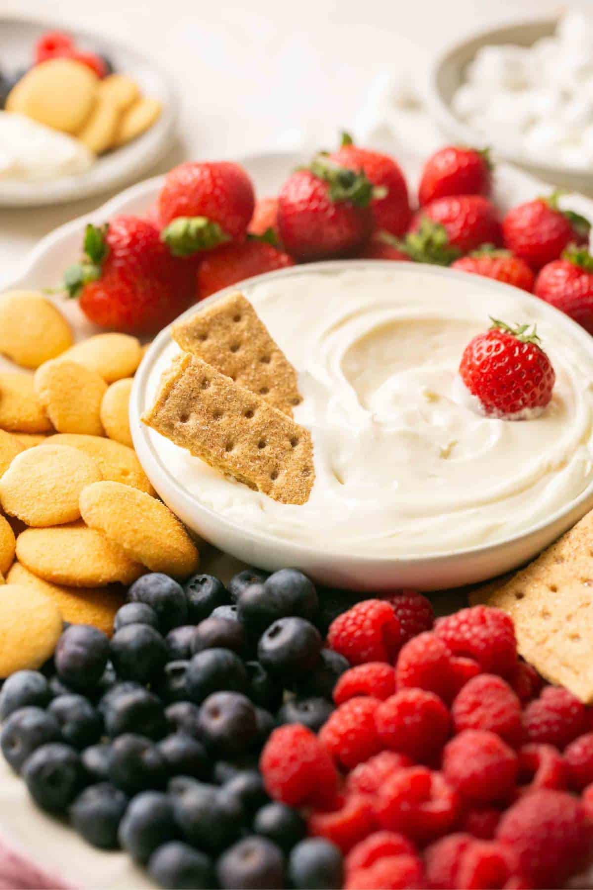Graham cracker sticks and a strawberry in a creamy dessert dip.