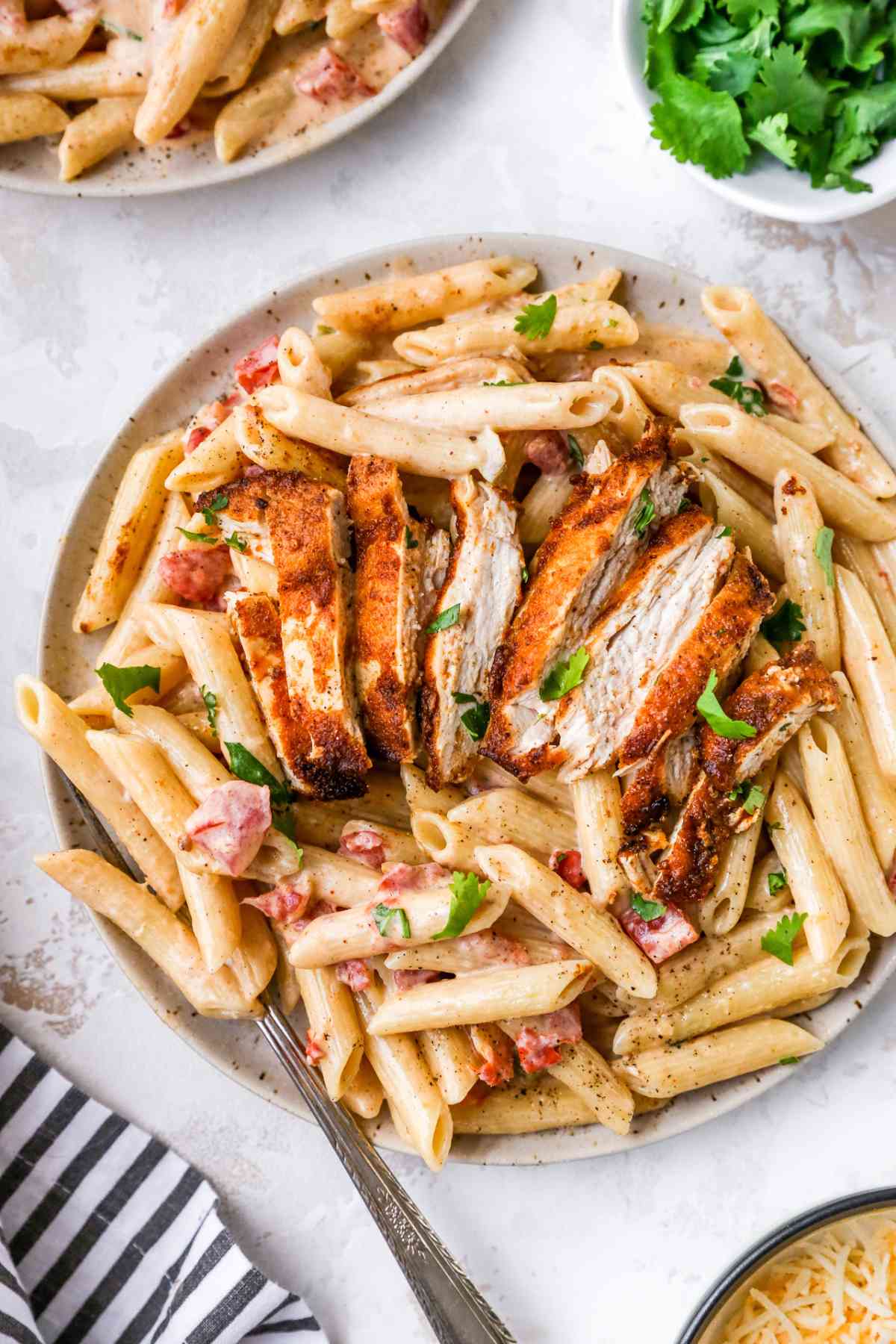 Sliced chicken over creamy penne pasta.