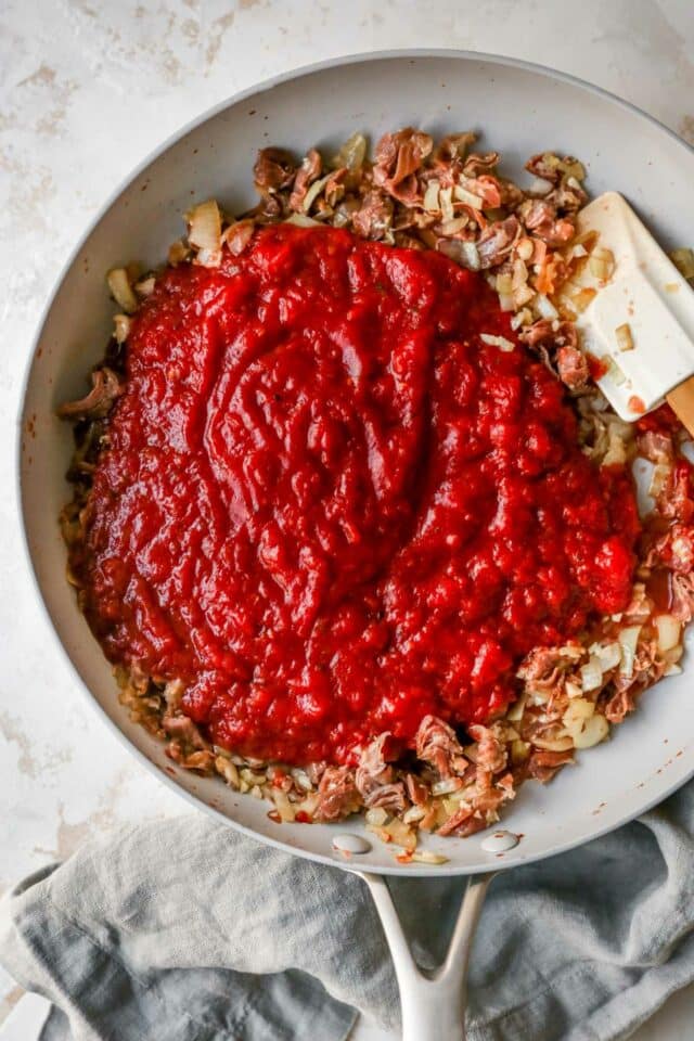 Stirring sauce with onion, garlic and prosciutto.