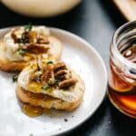 Goat cheese on a crostini with honey, pecans and thyme.