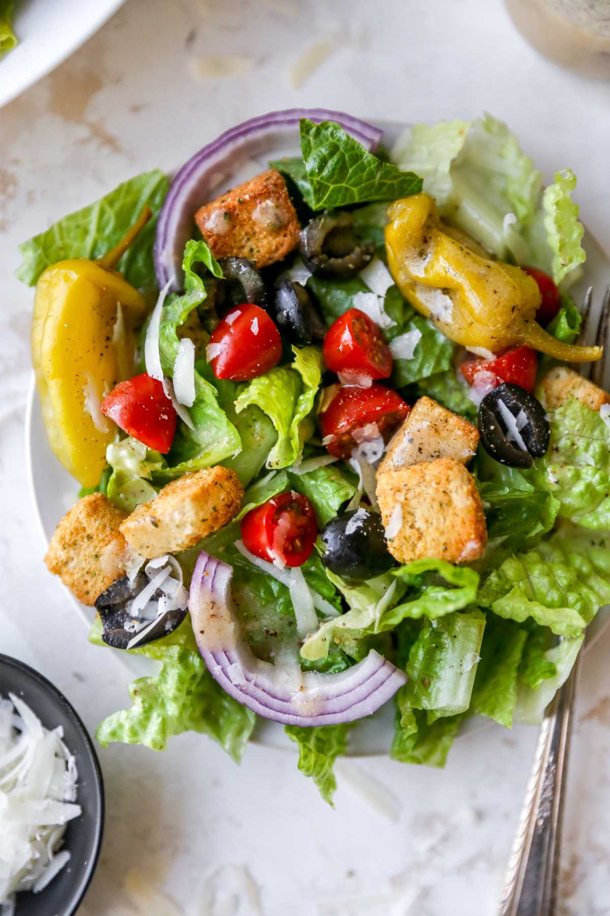 Salad topped with croutons, red onion, tomatoes and dressing.