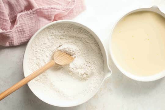 Whisking flour with baking powder in a large bowl.