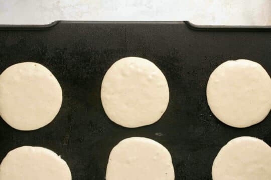 Adding pancake batter to a griddle.