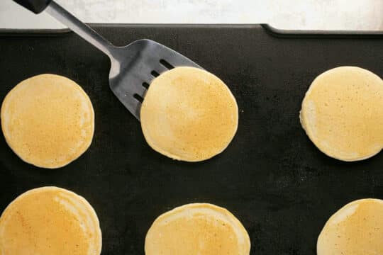 Flipping a pancake on a griddle.