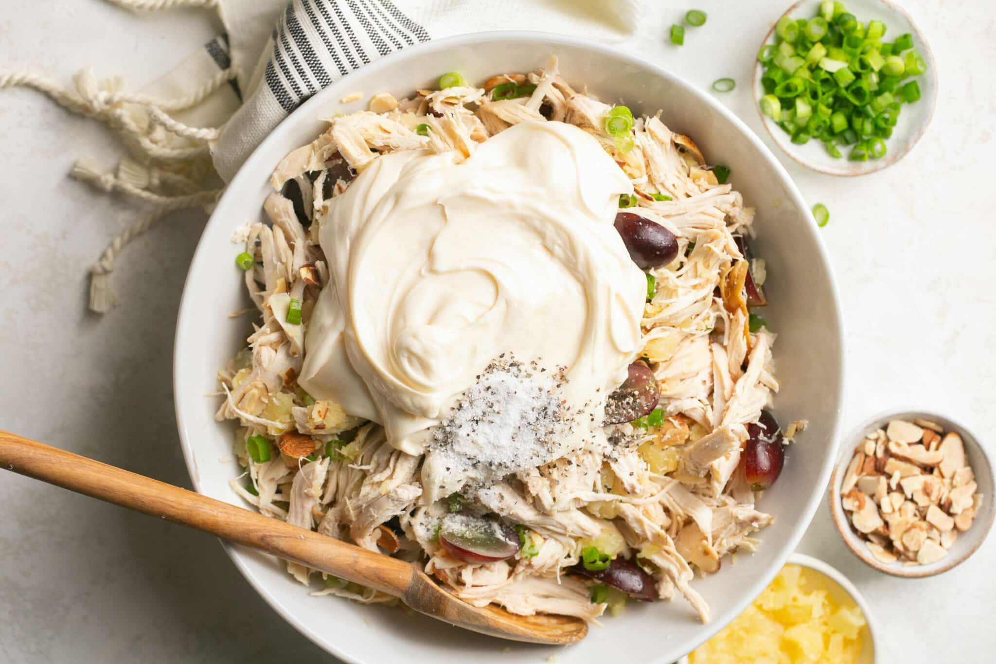 Adding mayo to bowl with shredded chicken.