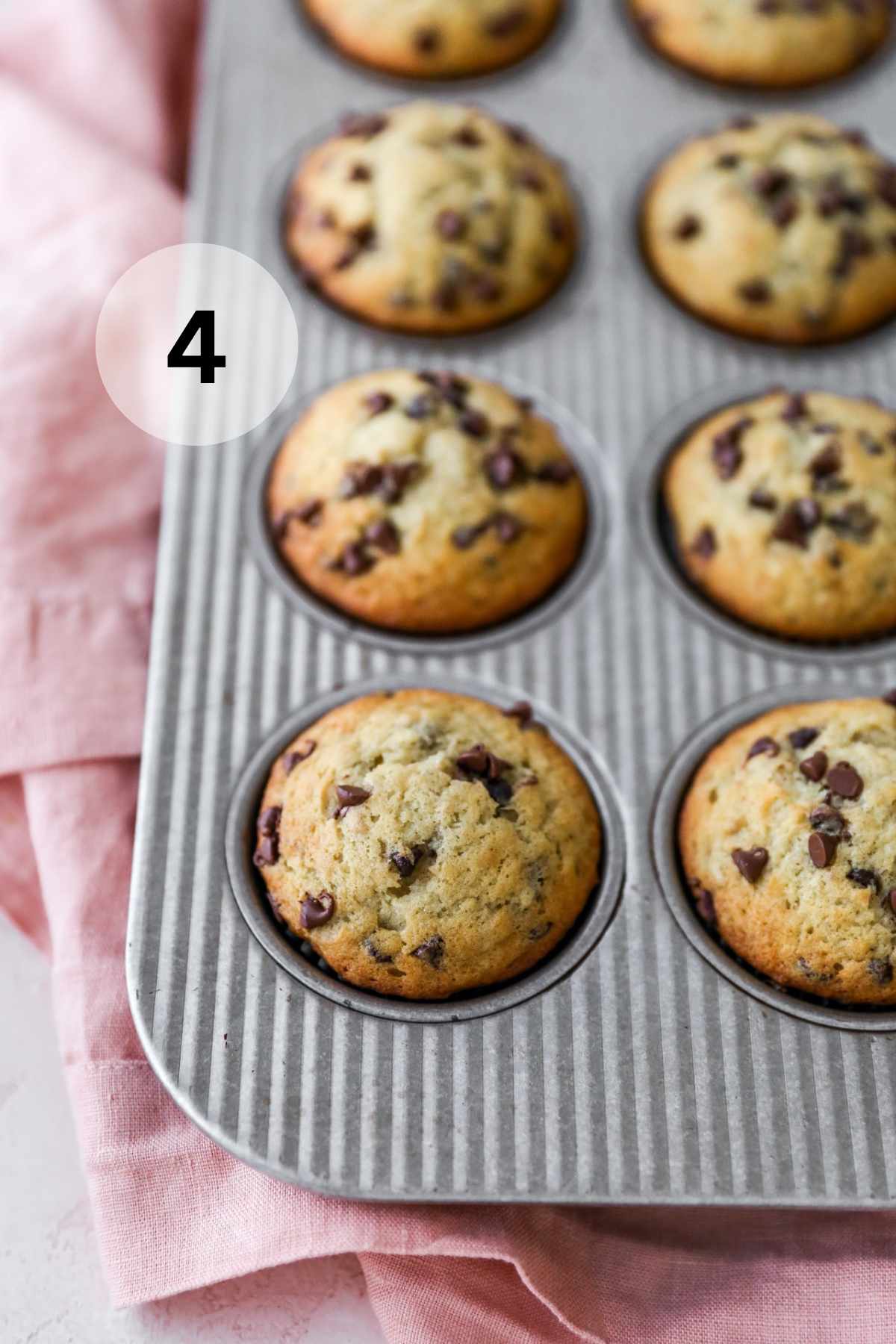 Chocolate chip banana muffins in a muffin pan.