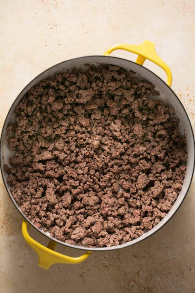 Ground beef browned in a large pan.