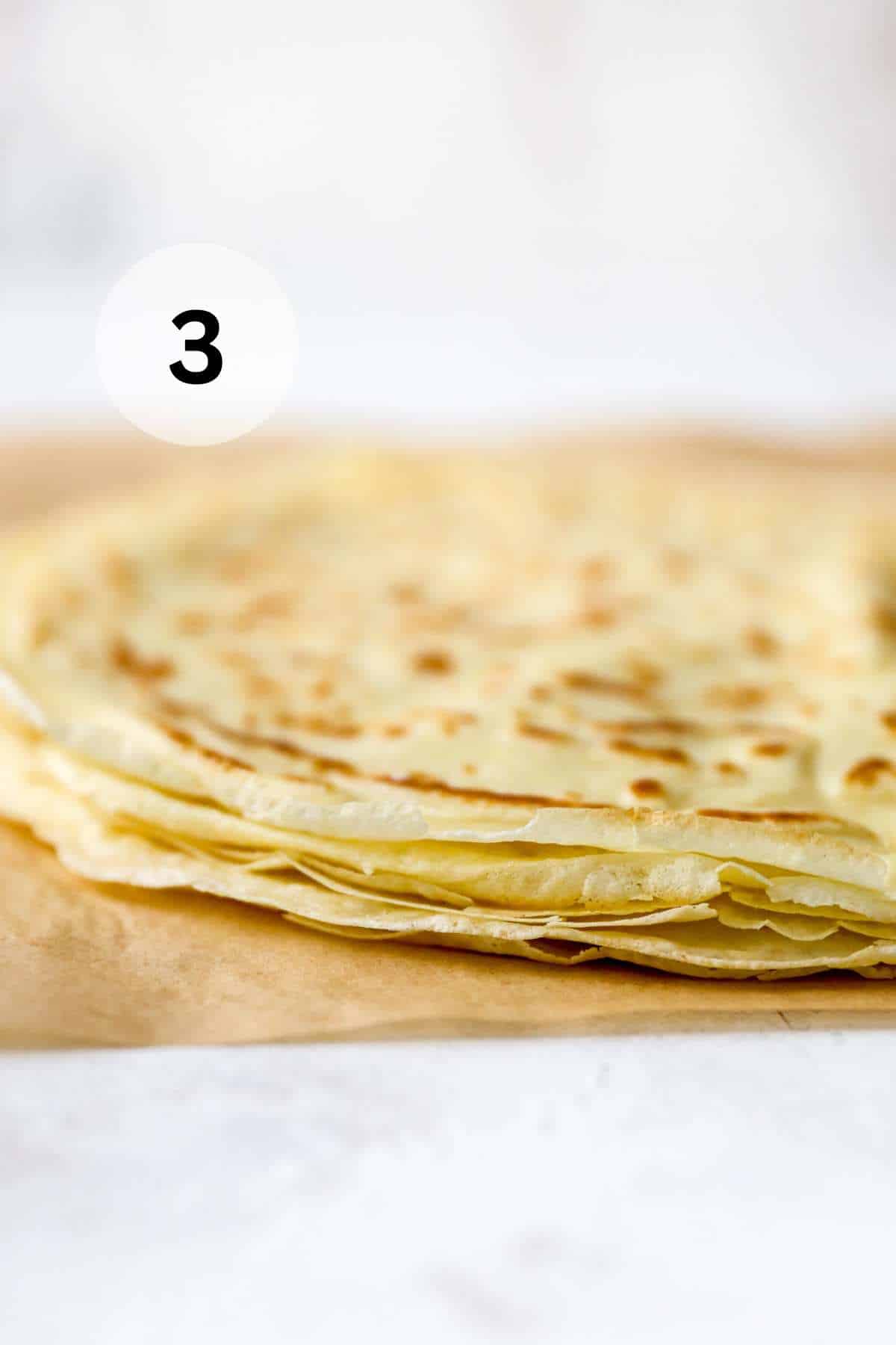 Then crepes stacked on parchment paper.