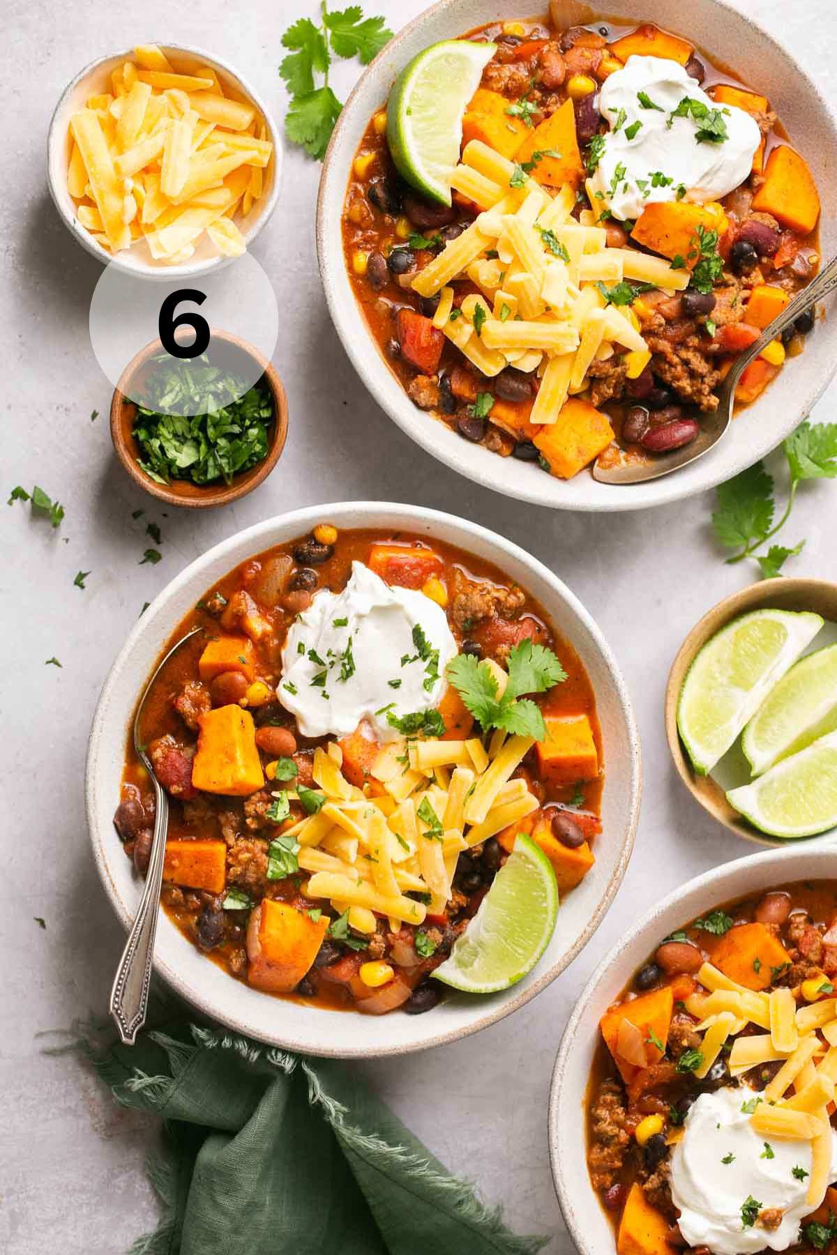 White bowls filled with sweet potato beef chili.