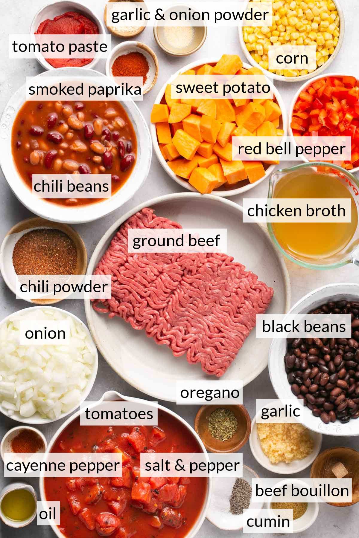 Small bowls with spices, sweet potato, beef, beans, onion, tomatoes and corn.