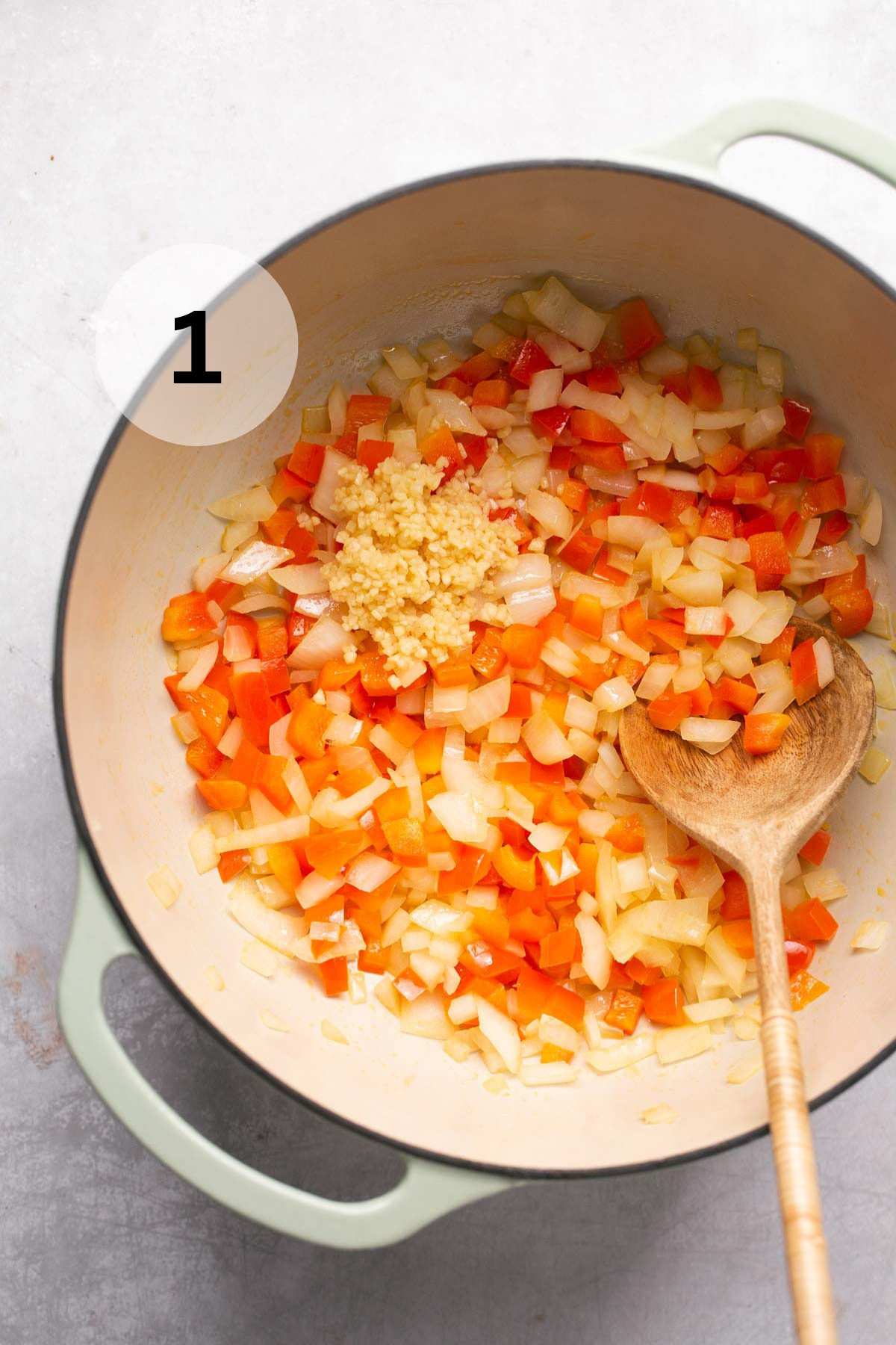 Sautéing onions and bell peppers in a large pot.
