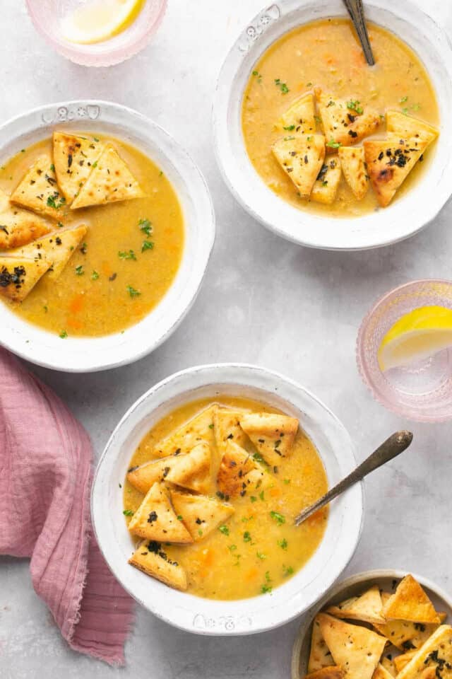 Bowls of soup topped with homemade pita chips. 