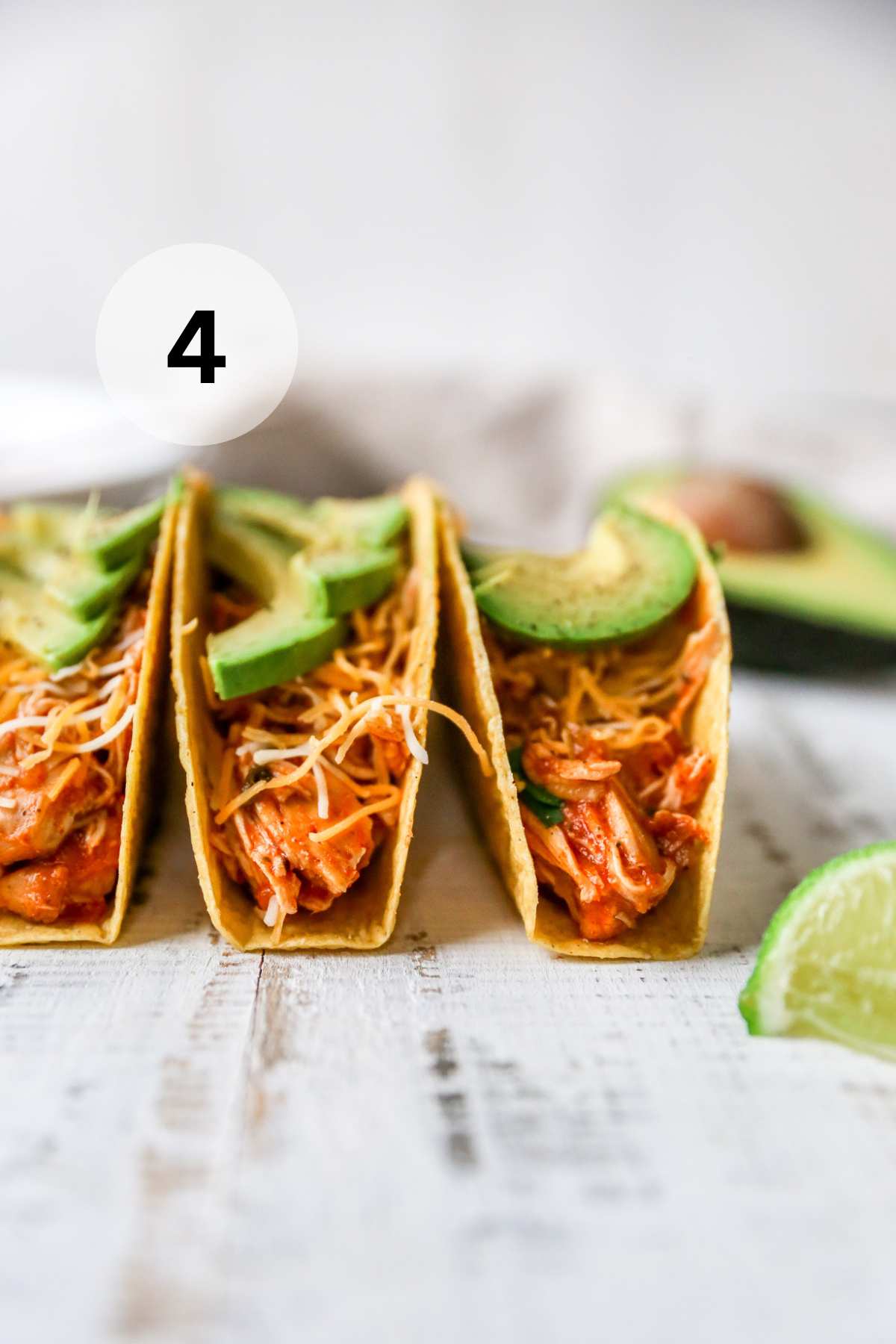 Salsa chicken served in tacos with avocado and cheese.