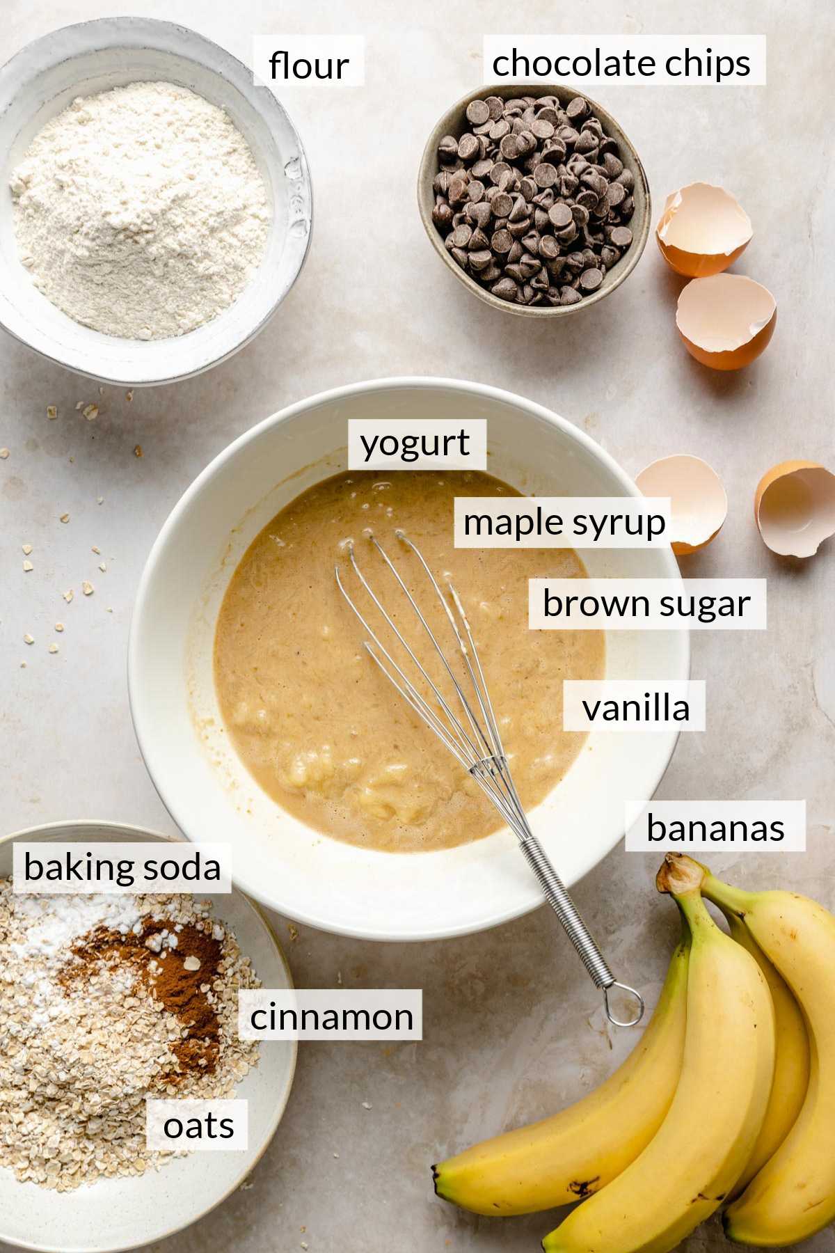 Bananas, flour, oats, chocolate chips and cracked eggs.