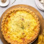 Quiche Lorraine garnished with fresh thyme.