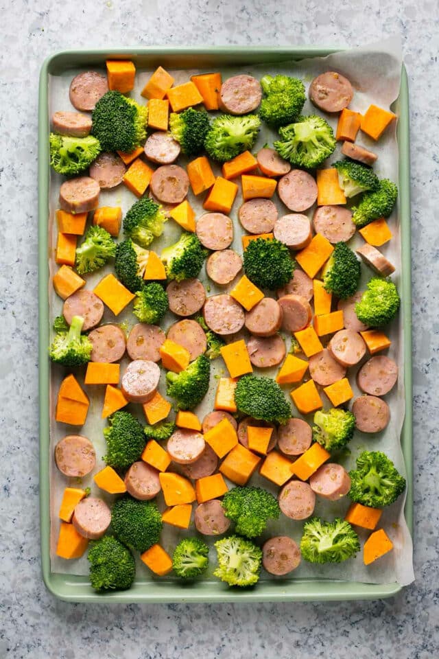 Sliced sausage and veggies drizzled with olive oil.