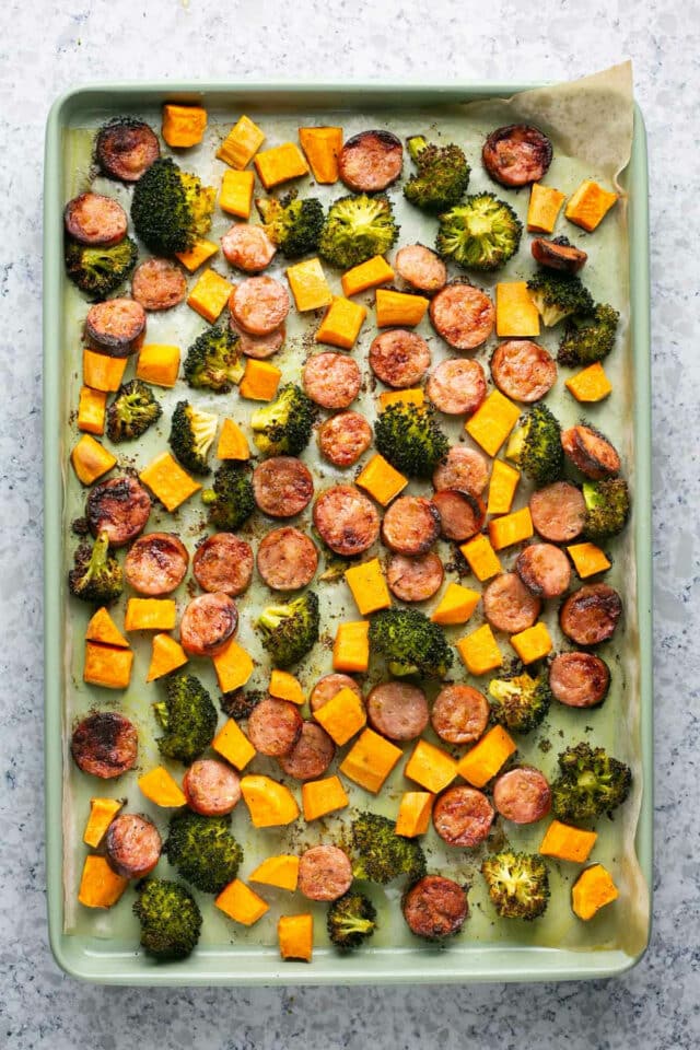 Sausage sheet pan dinner with roasted broccoli and sweet potato.