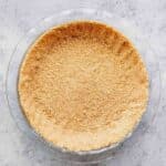 Homemade graham cracker crust in a glass pie dish.