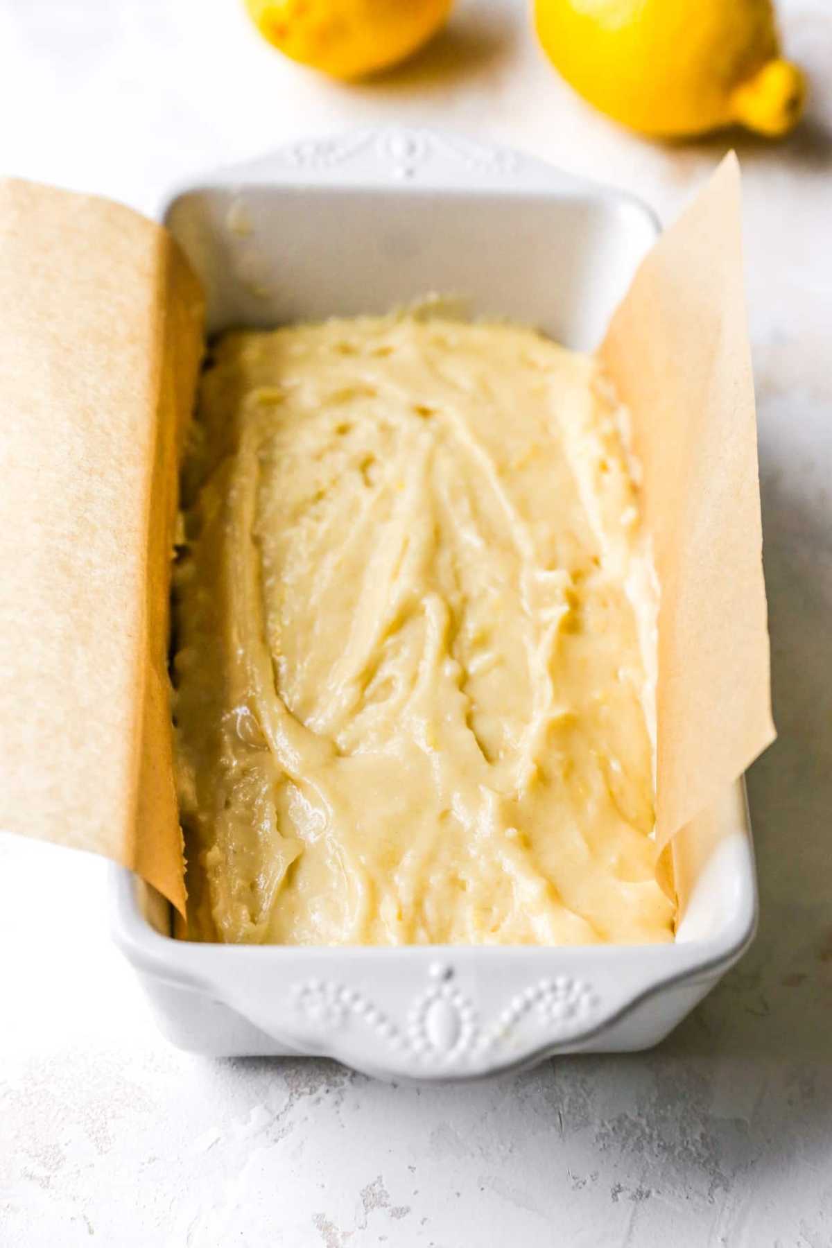 Batter in a loaf pan lined with parchment paper.