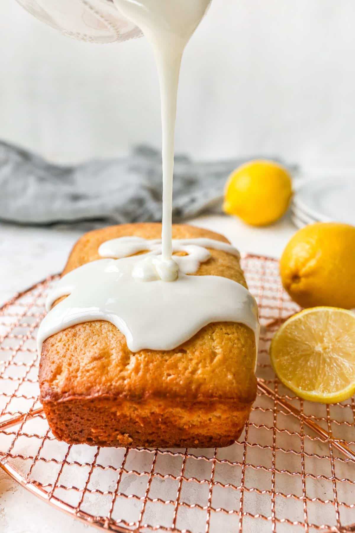 Pouring glaze over a pound cake on a wire rack.