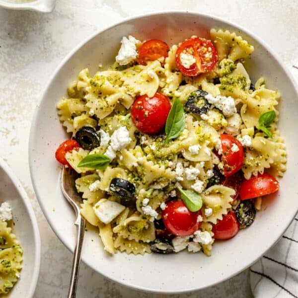Pesto pasta tossed with cherry tomatoes and black olives.