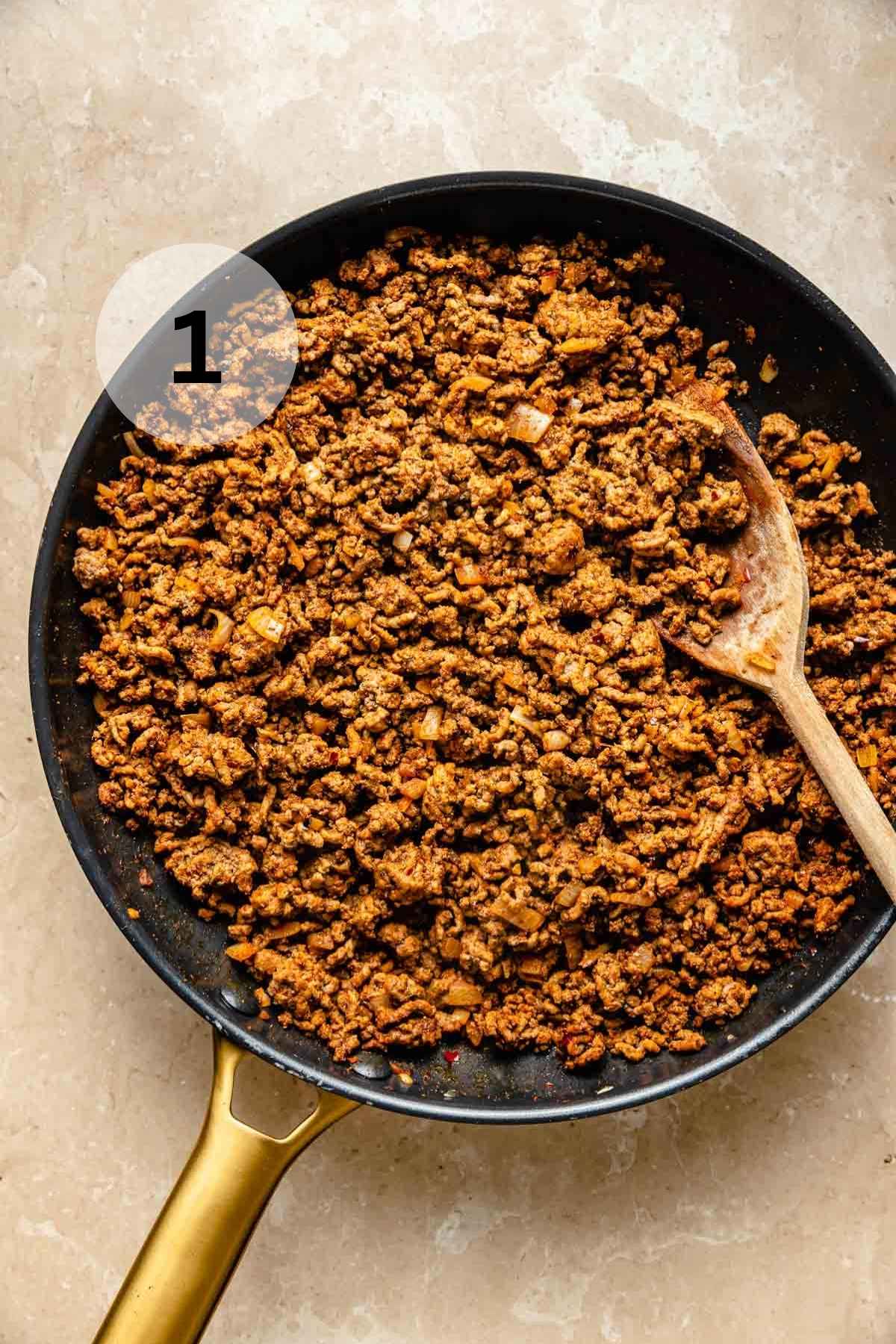 Cooking seasoned ground beef in a large skillet.