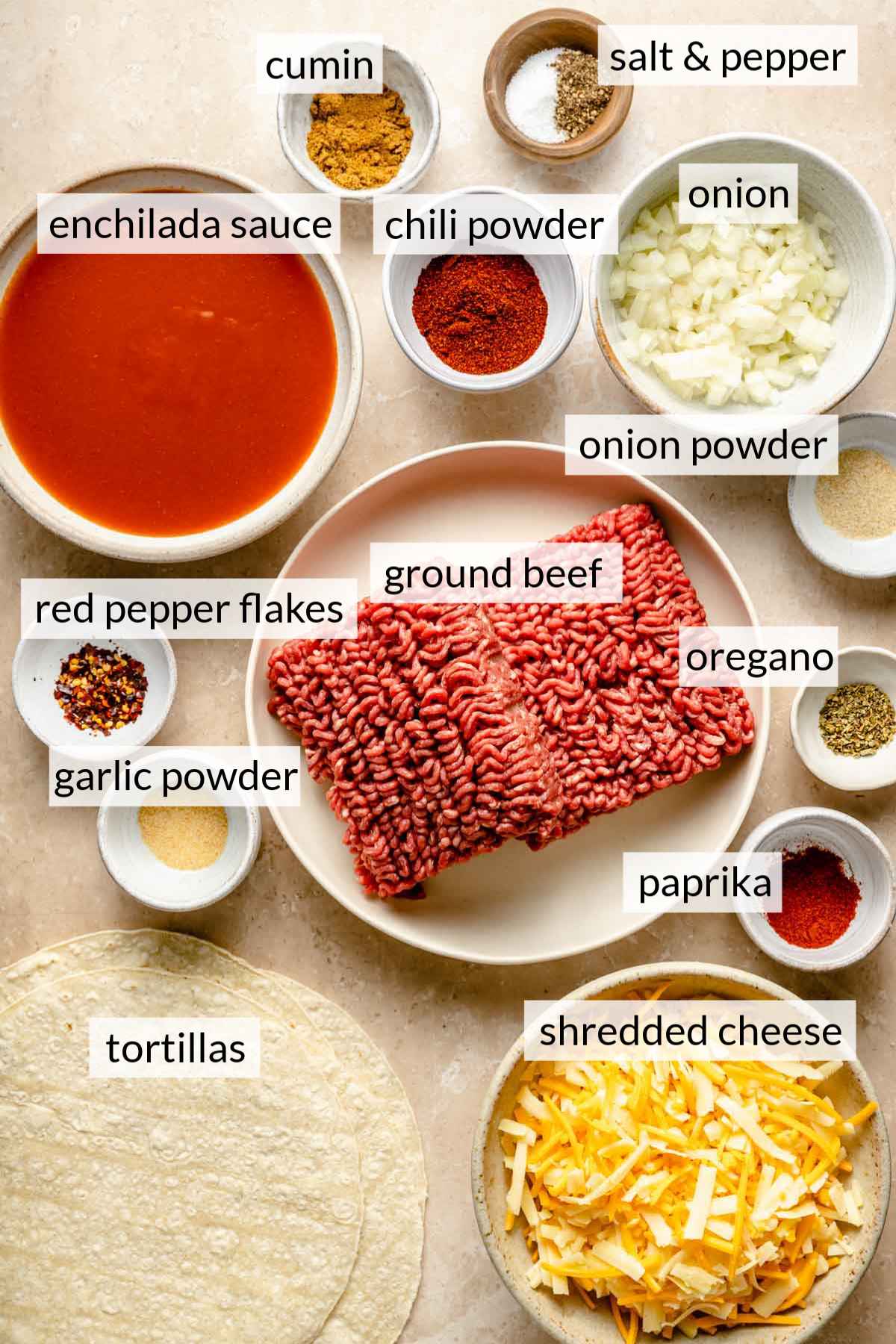Uncooked ground beef, spices and enchilada sauce divided into portions.