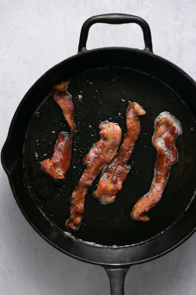 Frying bacon in a skillet.