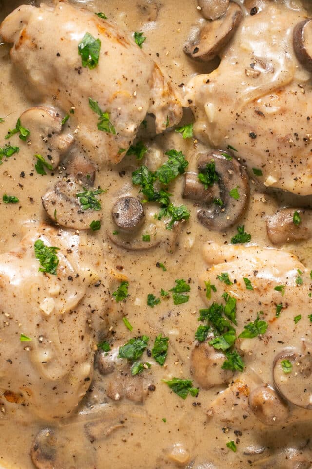 Mushroom gravy over chicken in a skillet.